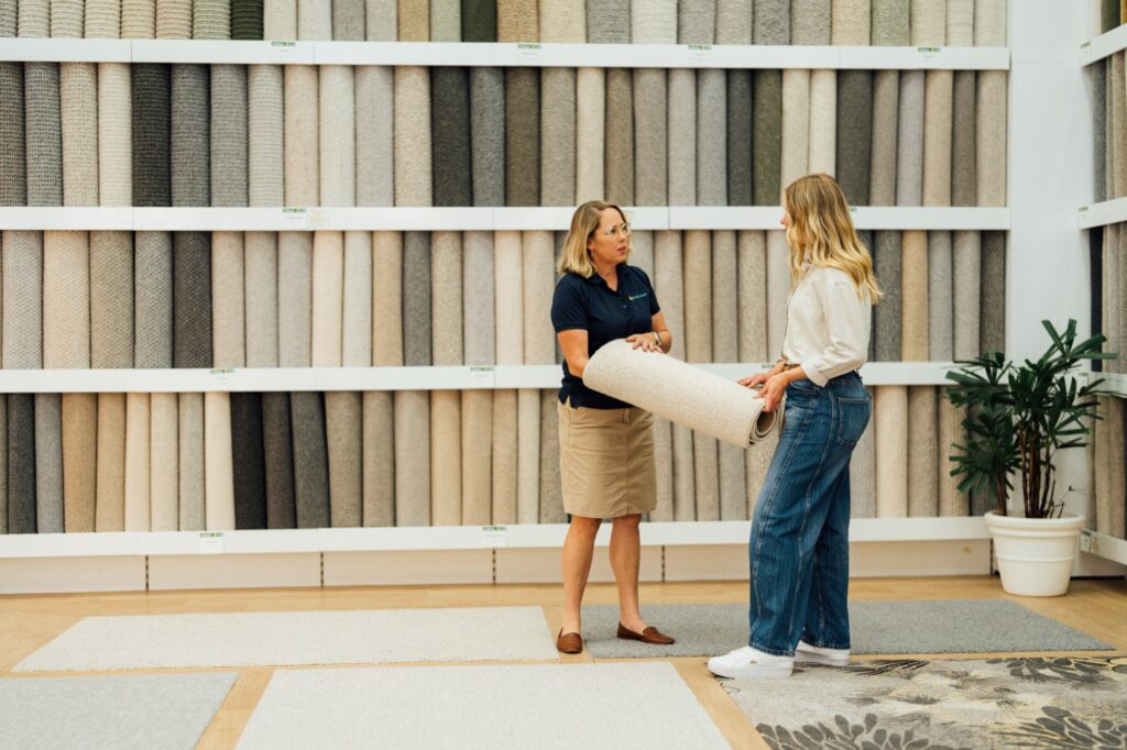 A customer being shown carpet against a wall of samples