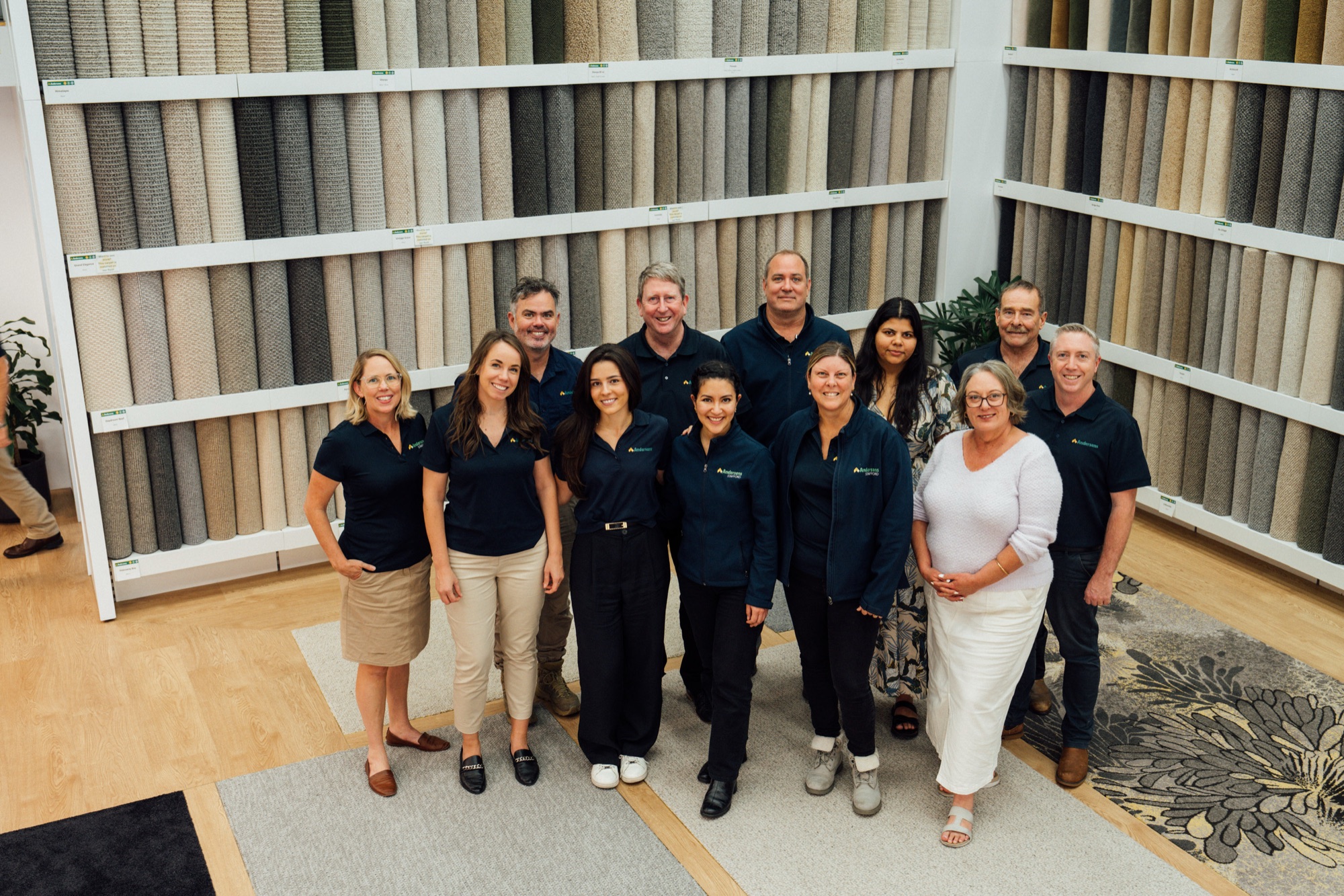 About a dozen Andersens staff standing together in front of the showroom sample racks