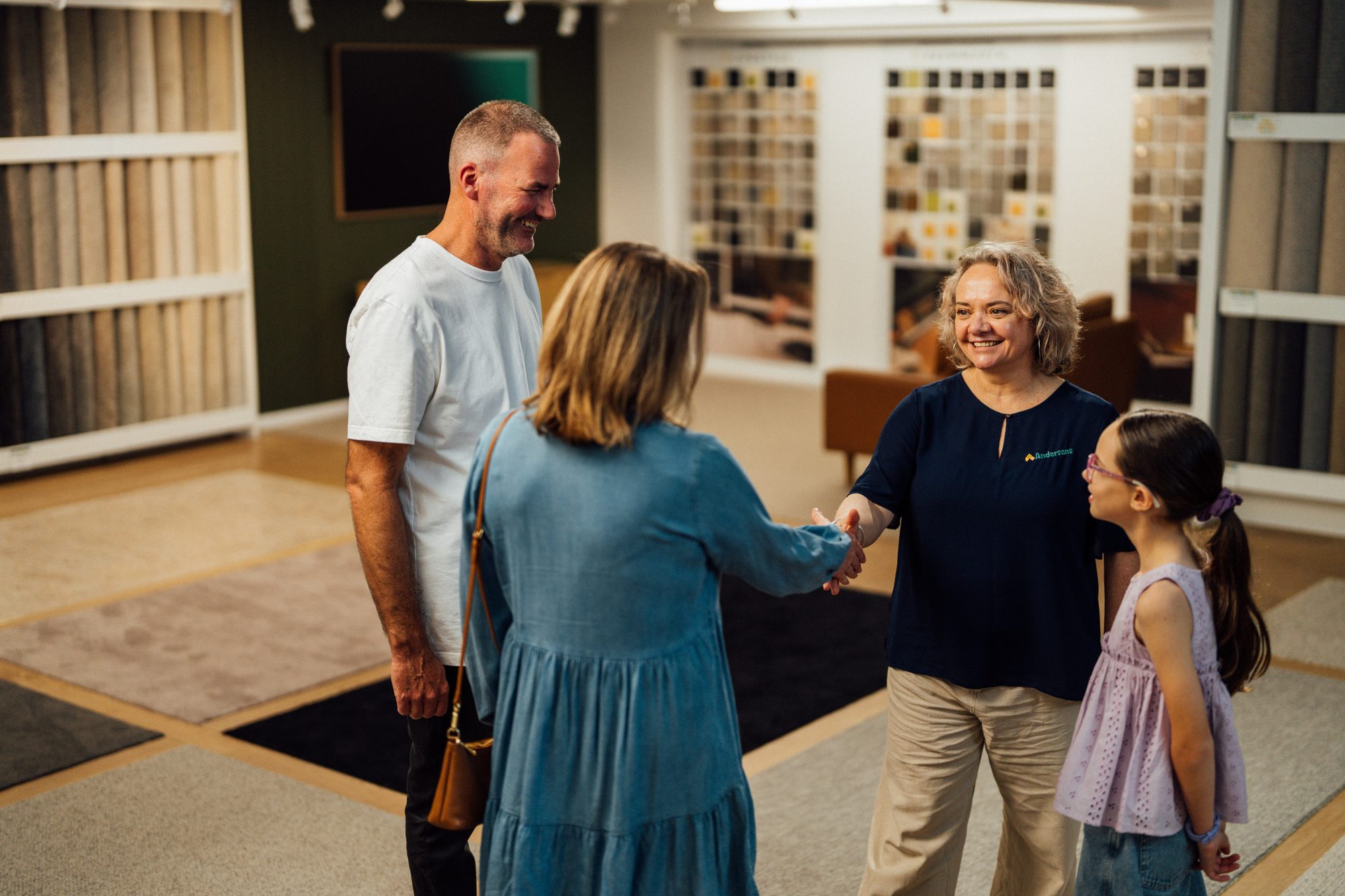 An Andersens store owner welcoming a family into the showroom