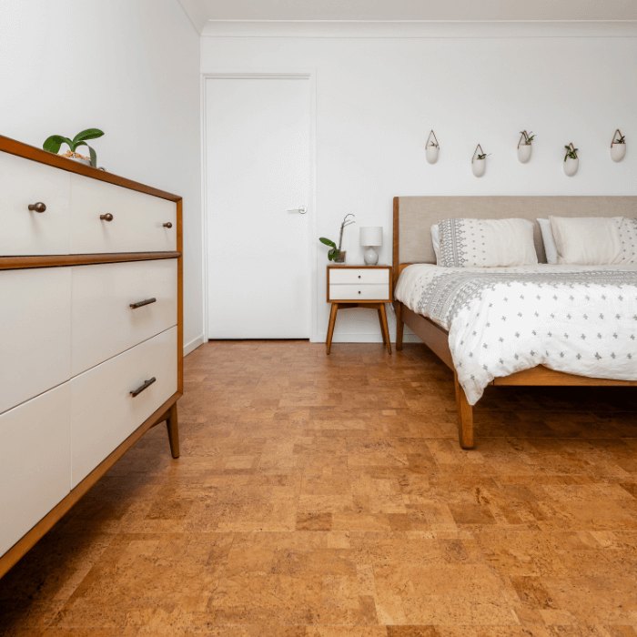 A honey-coloured cork floor in a bedroom with a made bed