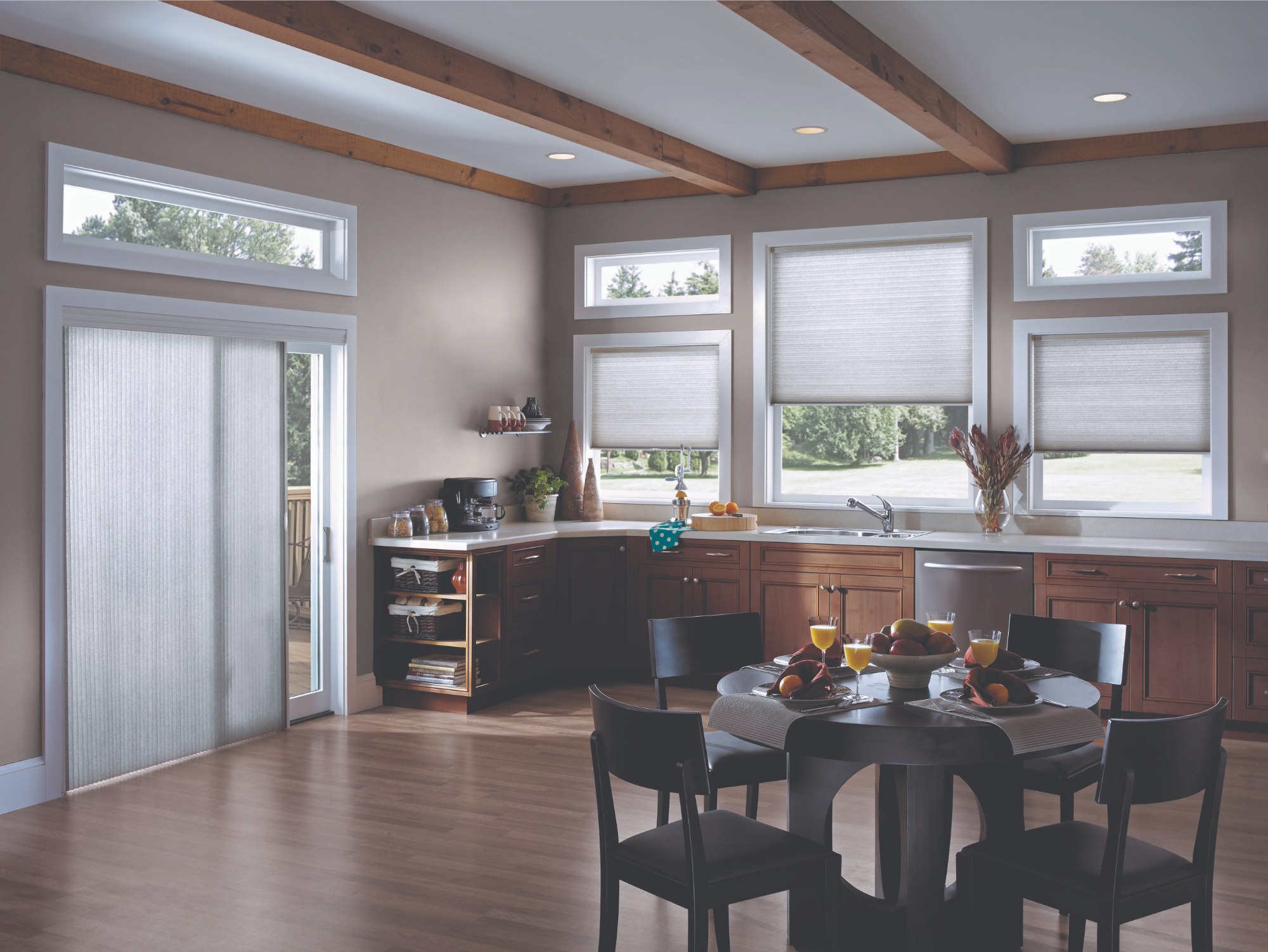 Cellular honeycomb blinds fitted across the windows of a kitchen and dining room