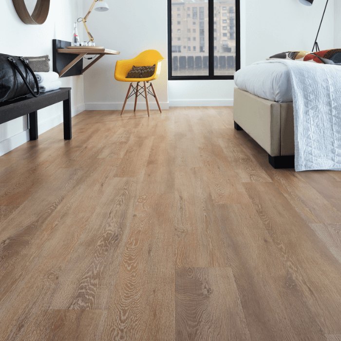 A timber-look plank floor running through a bedroom with a wall desk