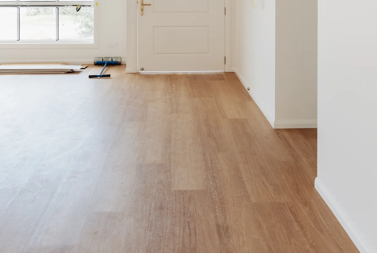 A newly laid vinyl plank floor in an empty room before furniture goes back in