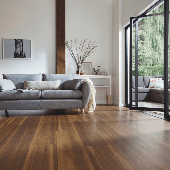 A dark timber-look plank floor in a living room with glazed doors to the garden