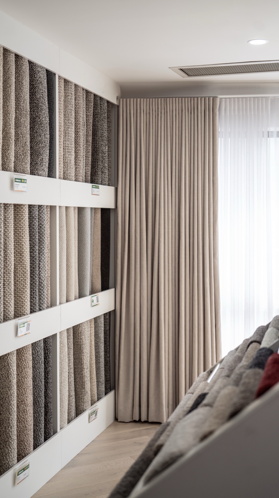 Curtain fabric samples hanging on display rails in an Andersens showroom