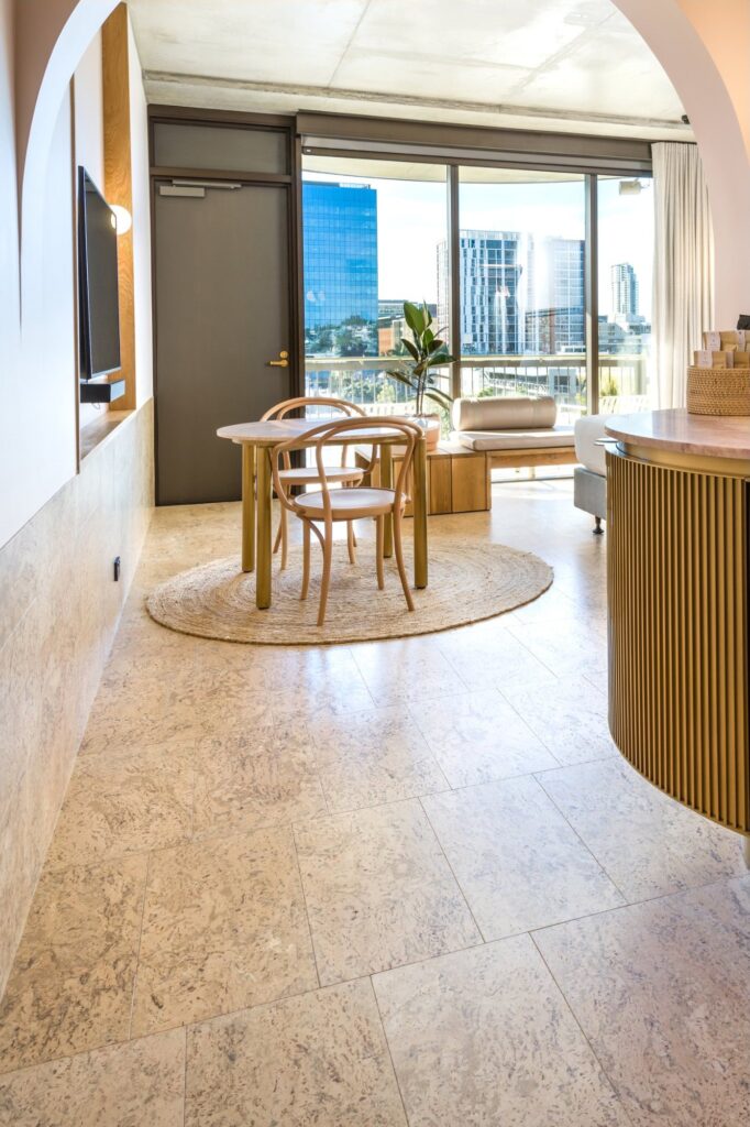 A cork floor in an apartment dining area with a city view beyond
