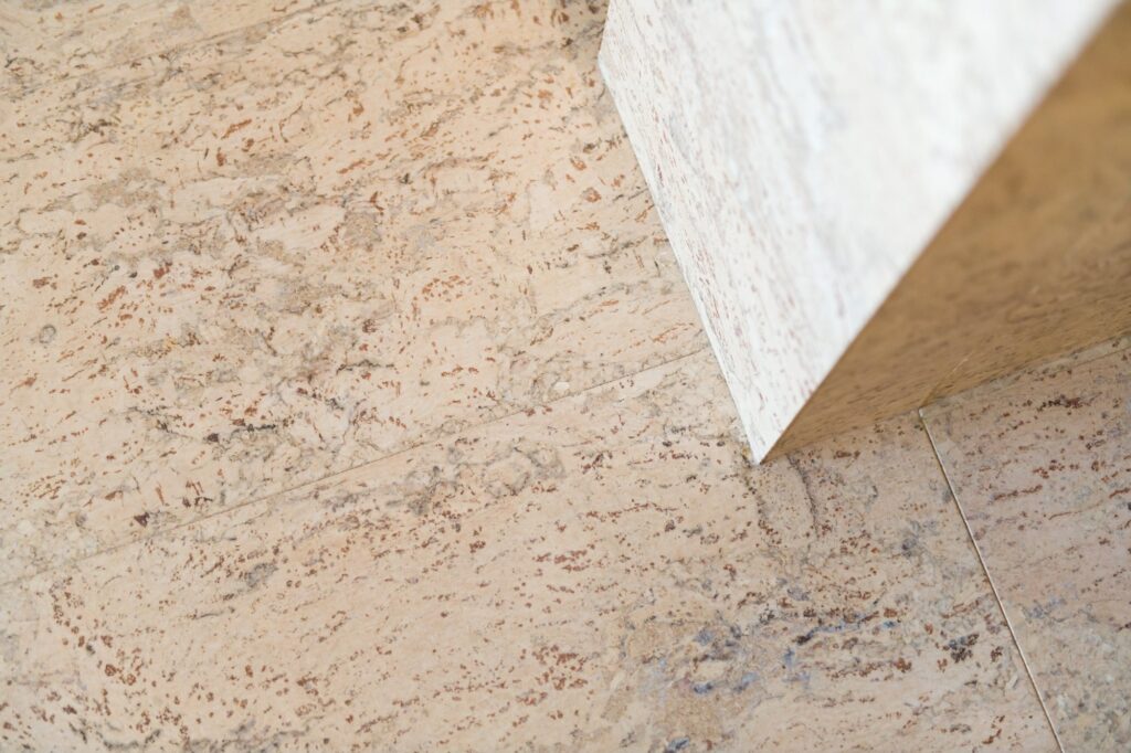 A close view of a pre-finished cork tile surface meeting a white skirting edge