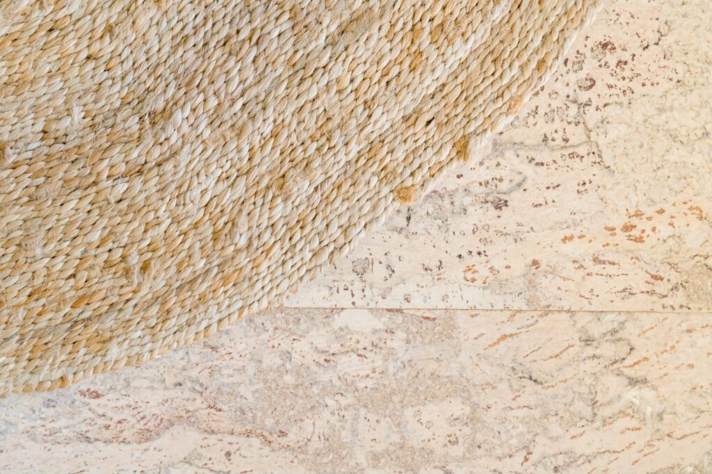 A close view of a cork floor surface showing its grain beside a woven rug