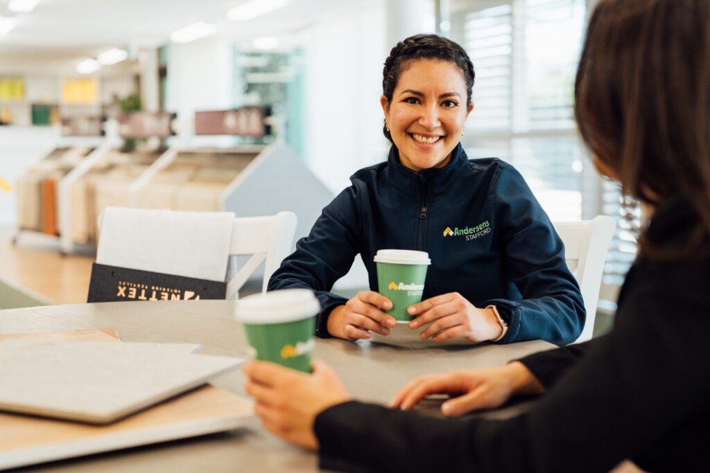An Andersens Stafford team member smiling across a table over coffee